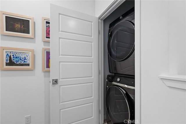 laundry area featuring stacked washer / drying machine