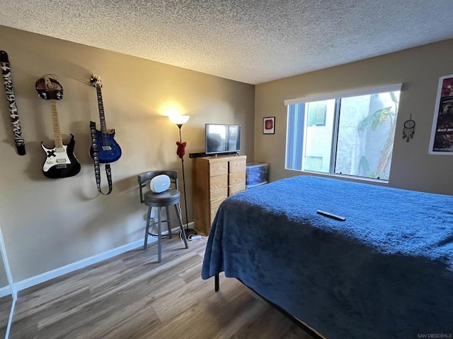 bedroom with wood-type flooring and a textured ceiling