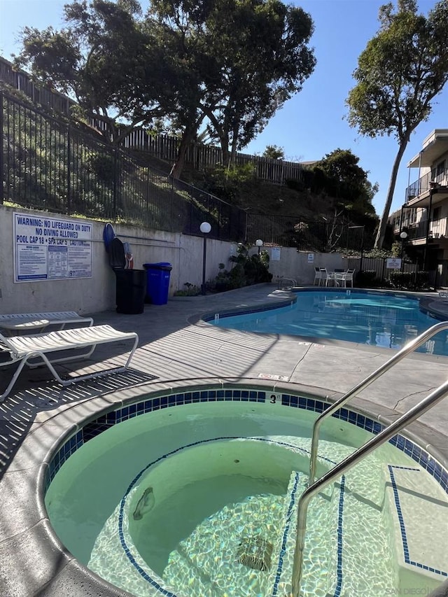 view of swimming pool featuring a community hot tub