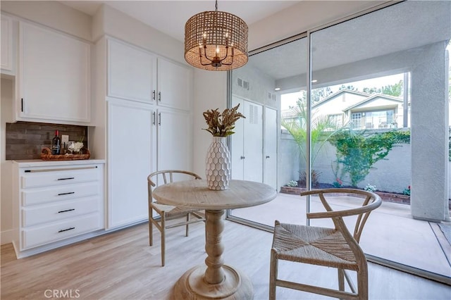 dining space with a chandelier and light hardwood / wood-style flooring