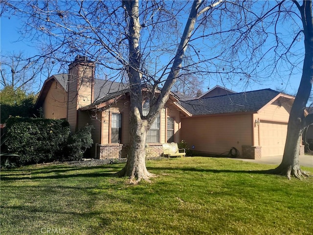 back of property featuring a yard and a garage