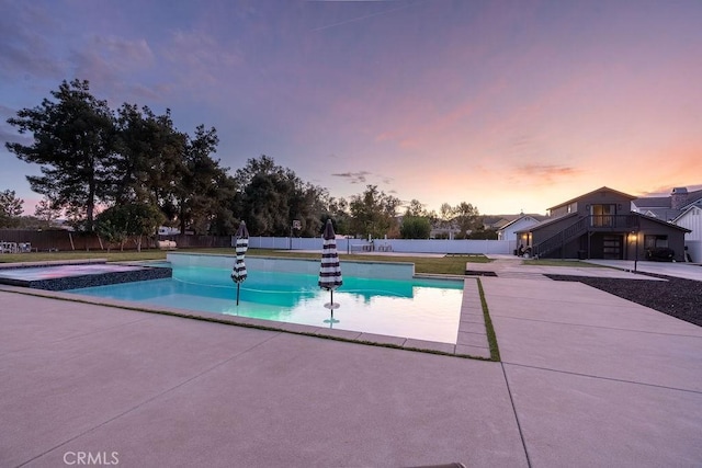 pool at dusk featuring a patio area