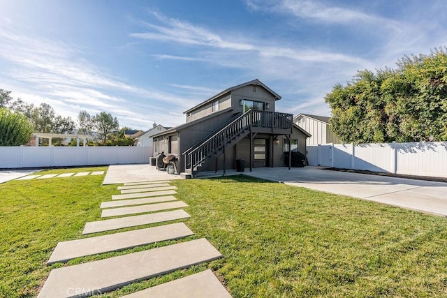 rear view of property with a lawn, a patio, and a deck