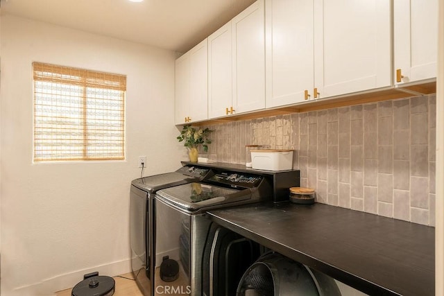 clothes washing area with cabinets and independent washer and dryer