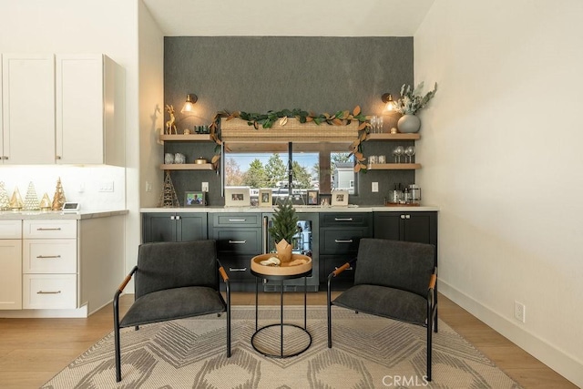 bar featuring wine cooler, light hardwood / wood-style floors, and white cabinets