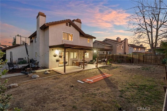 back house at dusk with a patio