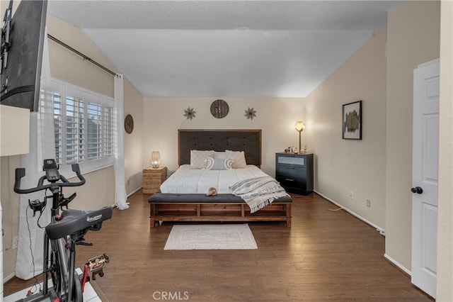 bedroom with lofted ceiling and dark hardwood / wood-style floors