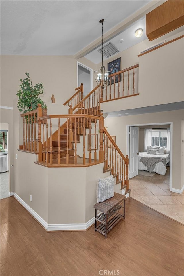 staircase featuring hardwood / wood-style flooring and a notable chandelier