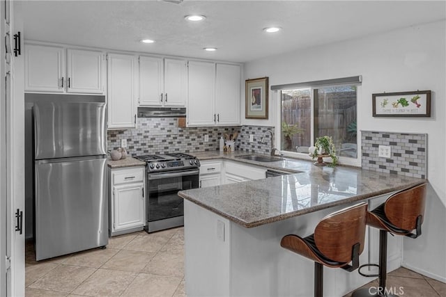 kitchen with sink, white cabinetry, tasteful backsplash, appliances with stainless steel finishes, and kitchen peninsula