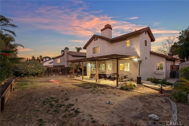 back house at dusk with a patio