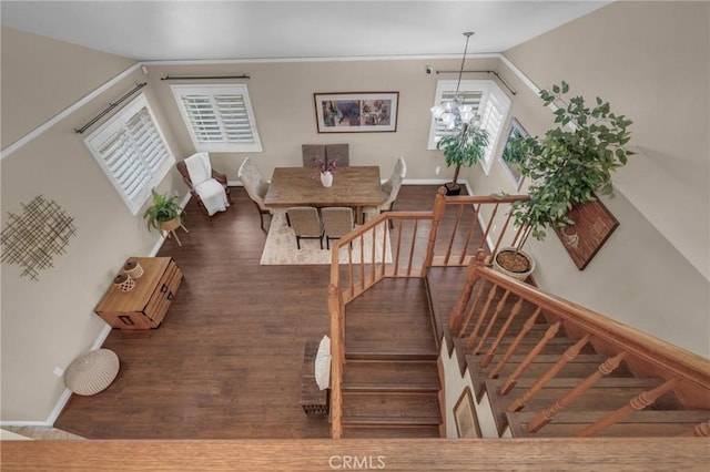 staircase with an inviting chandelier and wood-type flooring