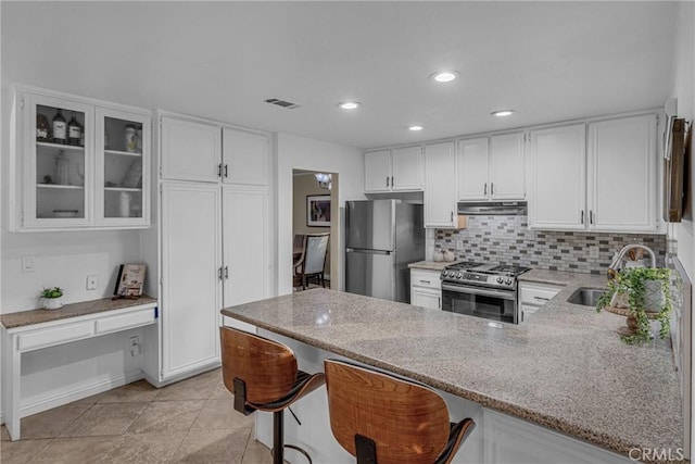 kitchen with stainless steel appliances, sink, white cabinets, and kitchen peninsula