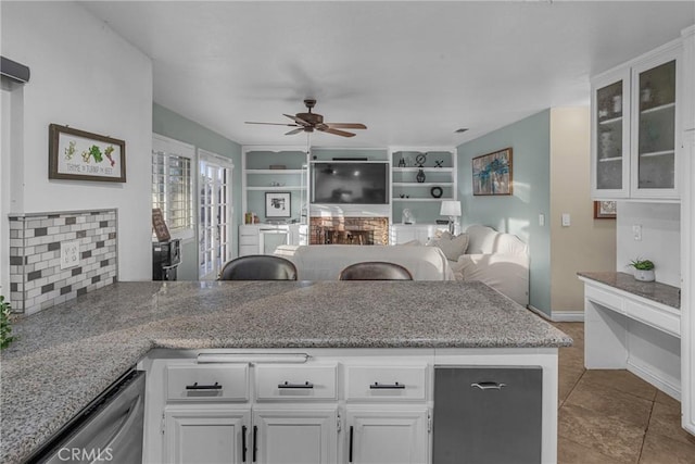 kitchen featuring white cabinetry, light tile patterned floors, stainless steel dishwasher, ceiling fan, and light stone countertops