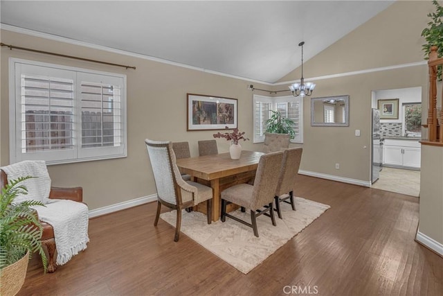 dining space featuring hardwood / wood-style flooring, lofted ceiling, and a notable chandelier