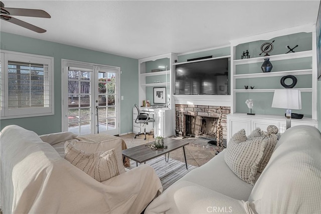 living room featuring a fireplace, french doors, and ceiling fan