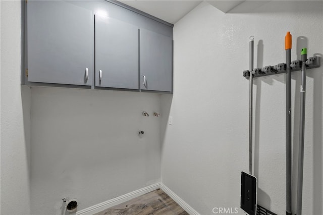 washroom featuring cabinets, hookup for a gas dryer, and hardwood / wood-style floors