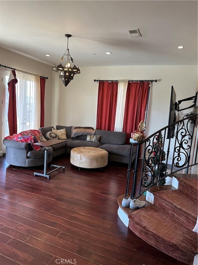 living room with dark hardwood / wood-style flooring and a chandelier