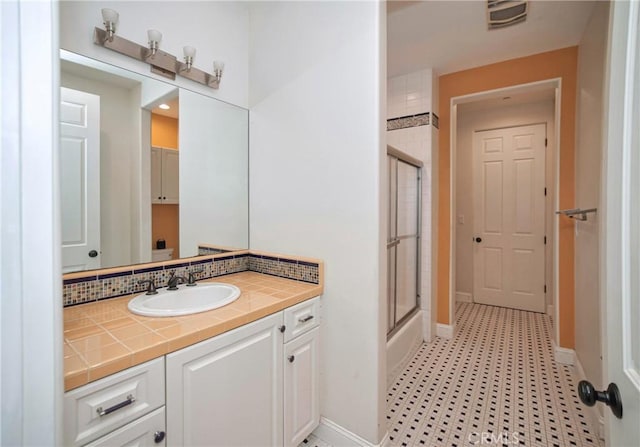 bathroom with tasteful backsplash and vanity