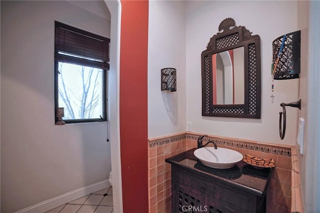 bathroom featuring vanity, tile patterned flooring, toilet, and tile walls