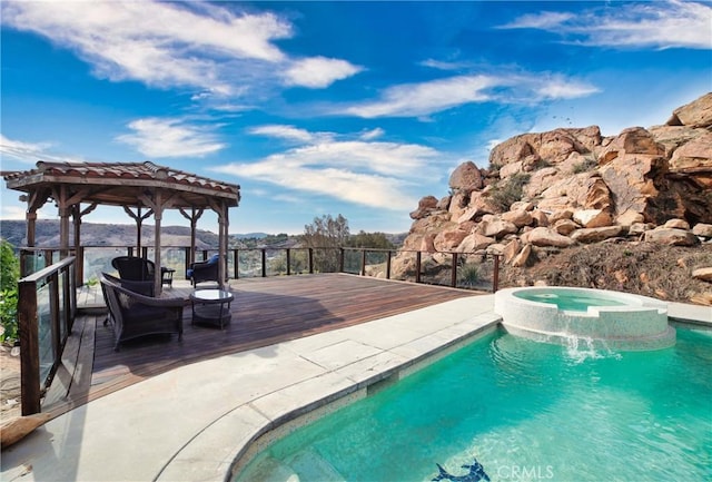 view of pool with a wooden deck, a gazebo, and an in ground hot tub