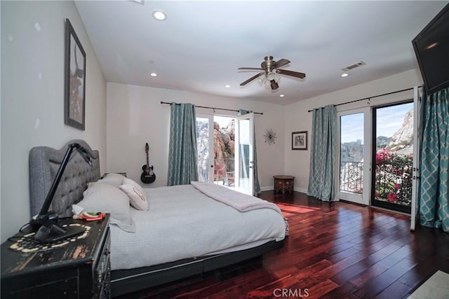 bedroom featuring multiple windows, dark hardwood / wood-style floors, and access to exterior