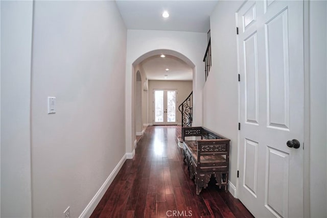 corridor with dark hardwood / wood-style flooring and french doors