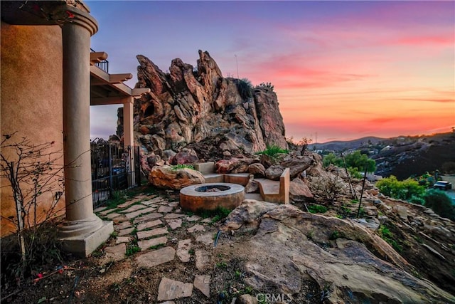 yard at dusk featuring a patio area and a fire pit