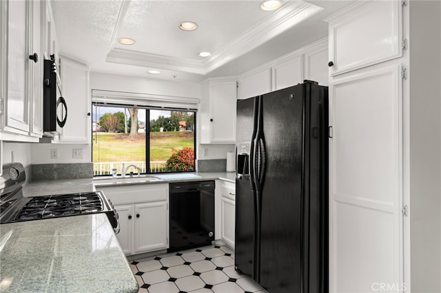 kitchen featuring sink, a tray ceiling, black appliances, light stone countertops, and white cabinets