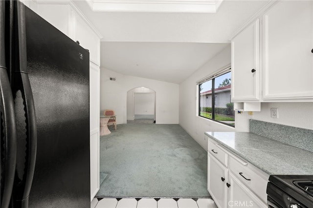 kitchen with white cabinetry, lofted ceiling, light colored carpet, and black appliances