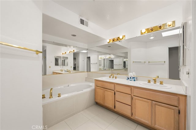 bathroom featuring vanity, a relaxing tiled tub, and tile patterned floors