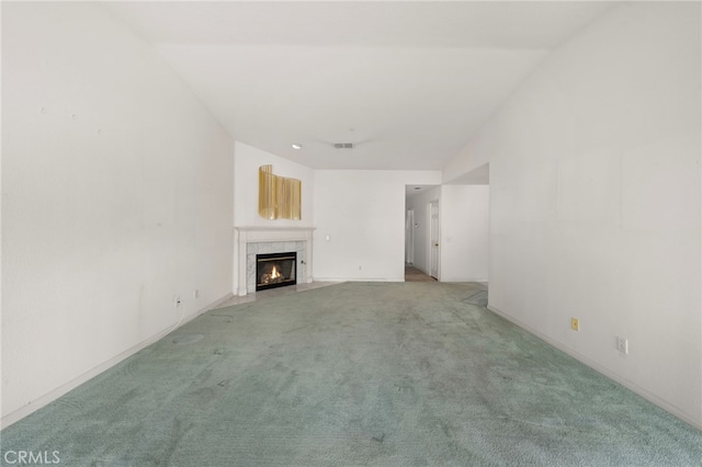 unfurnished living room featuring vaulted ceiling, carpet, and a fireplace