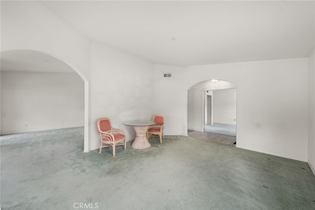 empty room featuring vaulted ceiling and carpet