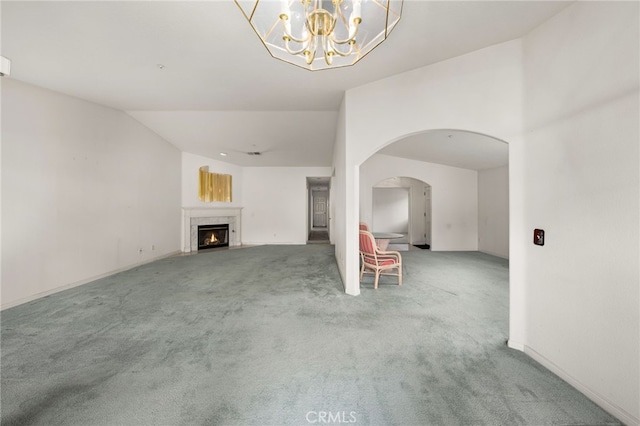 unfurnished living room with vaulted ceiling and carpet flooring