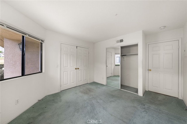 unfurnished bedroom featuring two closets and carpet floors