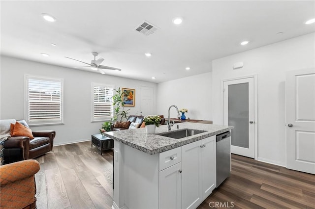 kitchen with dishwasher, wood-type flooring, sink, white cabinets, and a kitchen island with sink