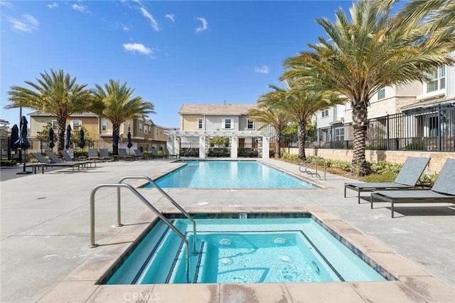 view of swimming pool featuring a community hot tub, a patio area, and a pergola