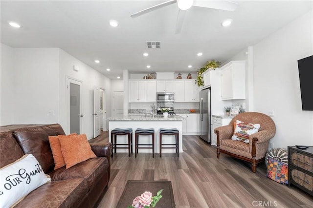 living room with ceiling fan, wood-type flooring, and sink