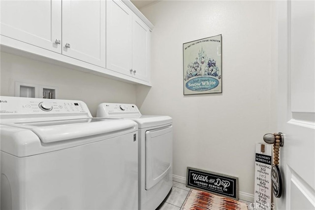 laundry area with separate washer and dryer, cabinets, and light tile patterned flooring