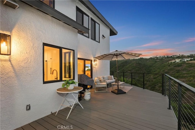 deck at dusk featuring sink and an outdoor hangout area