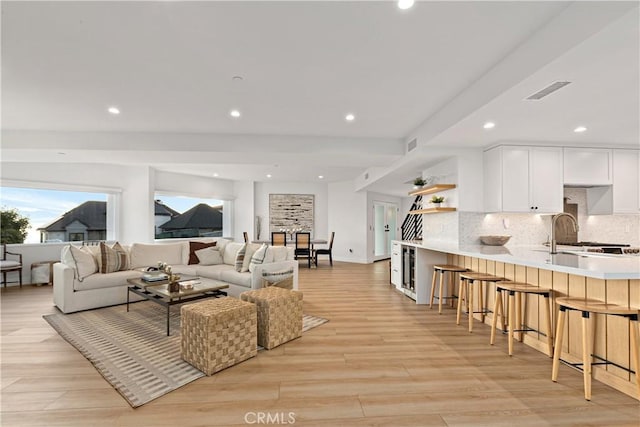 living room with sink and light hardwood / wood-style floors