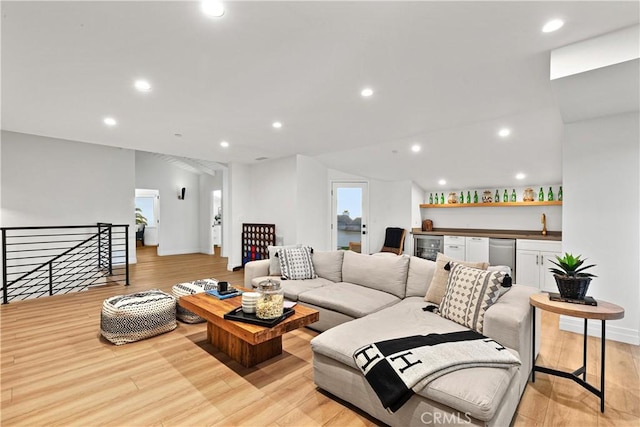 living room featuring wine cooler, indoor bar, and light wood-type flooring