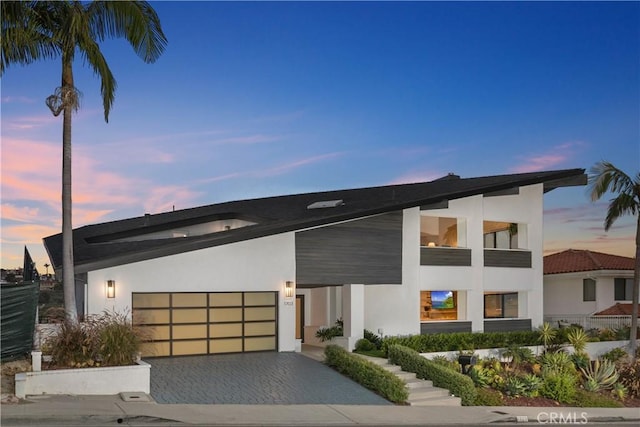 contemporary house with stucco siding, driveway, and an attached garage