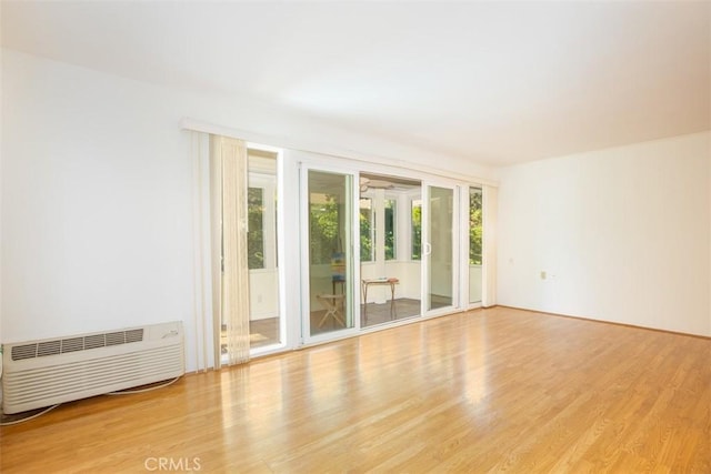 465 Avenida Sevilla Unit C, Laguna Woods, CA 92637 - unfurnished room with light wood finished floors and an AC wall unit