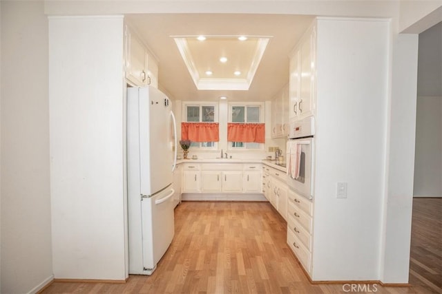 465 Avenida Sevilla Unit C, Laguna Woods, CA 92637 - kitchen featuring white appliances, a tray ceiling, light wood-type flooring, recessed lighting, and light countertops