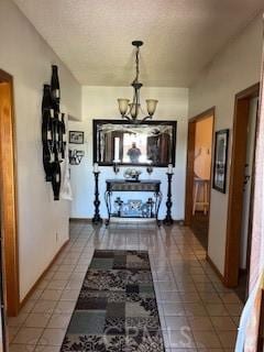 hallway with tile patterned flooring and a chandelier