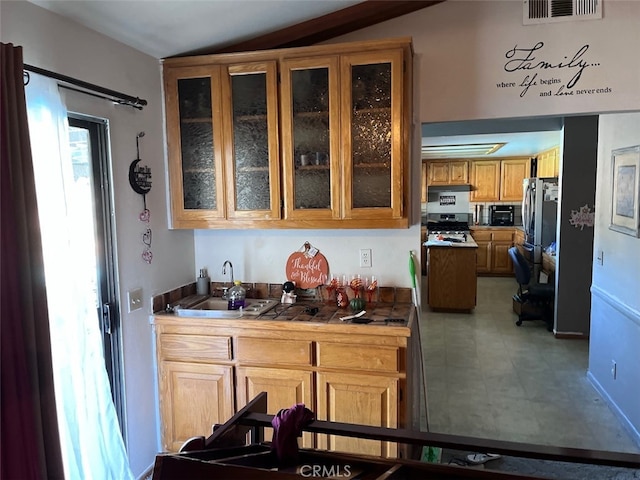 kitchen featuring sink, tile countertops, and stainless steel range