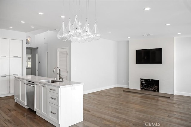 kitchen featuring white cabinetry, sink, and a center island with sink