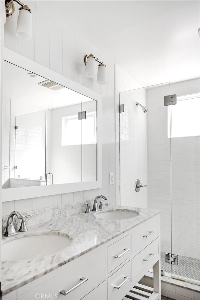 bathroom featuring walk in shower, a healthy amount of sunlight, and vanity