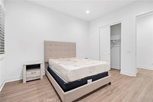 bedroom with light hardwood / wood-style flooring and a closet