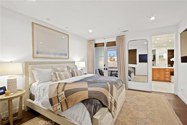 bedroom featuring visible vents, recessed lighting, ensuite bathroom, wood finished floors, and access to outside